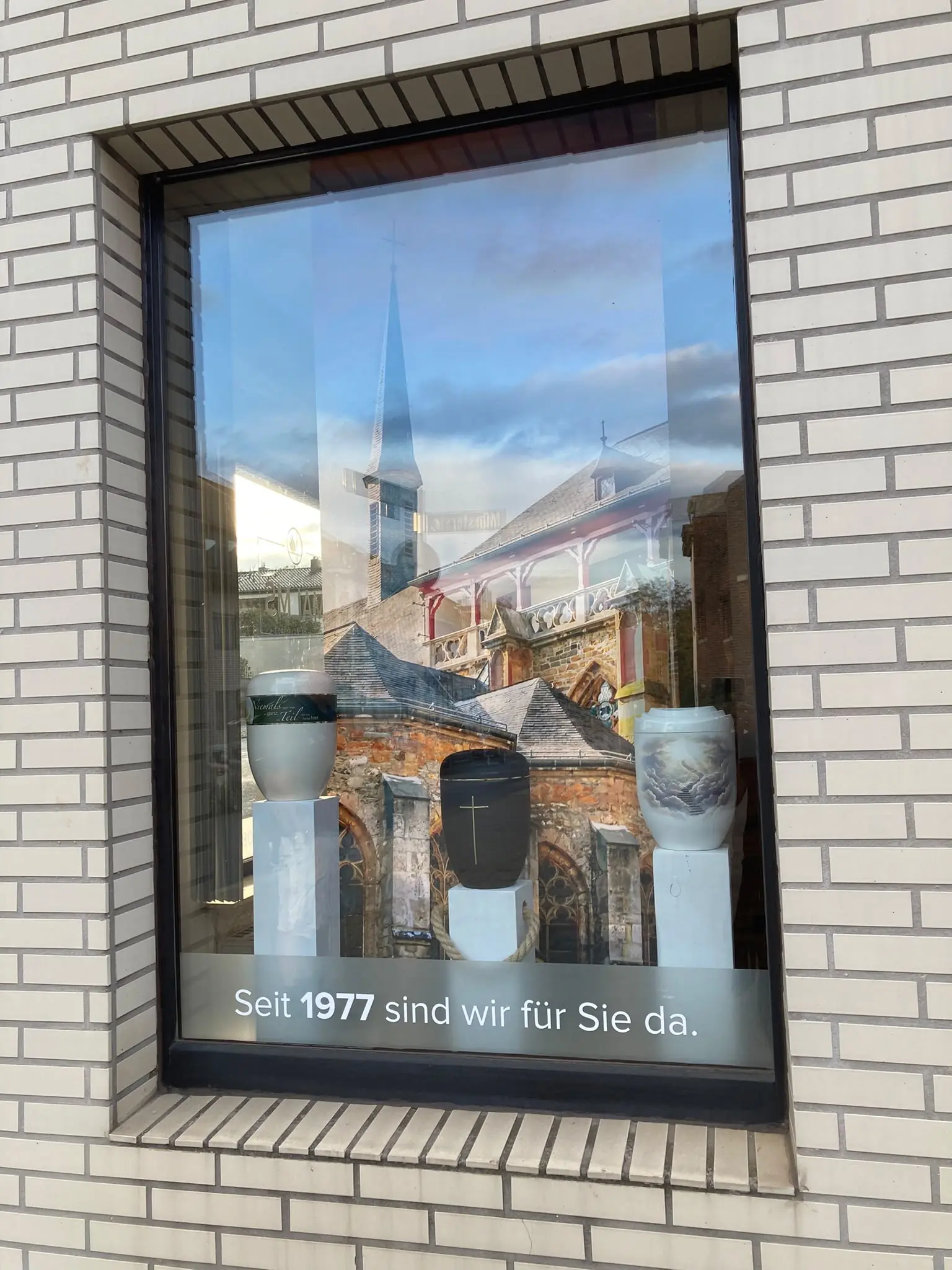 Schaufenster mit drei Urnen auf weißen Sockeln und dem Schriftzug Seit 1977 sind wir für Sie da